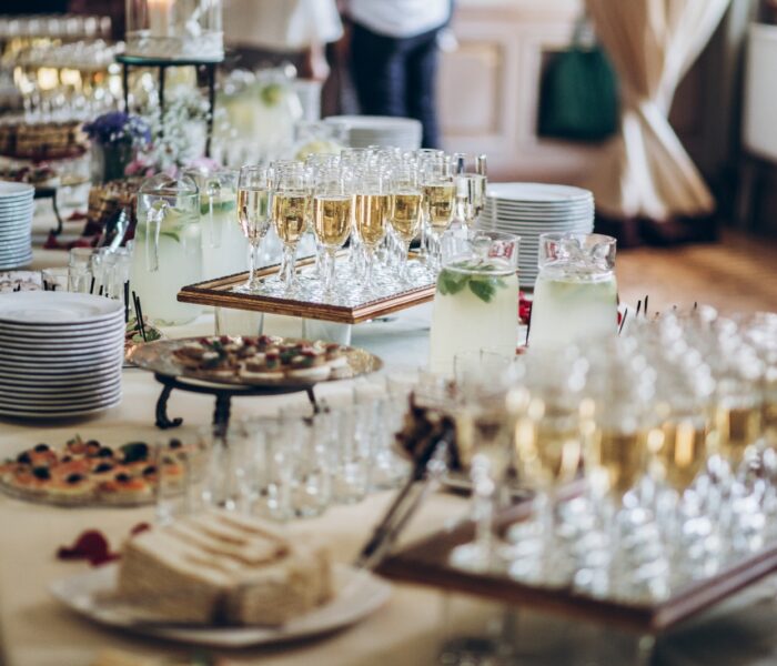 Stylish champagne glasses and food  appetizers on table at wedding reception